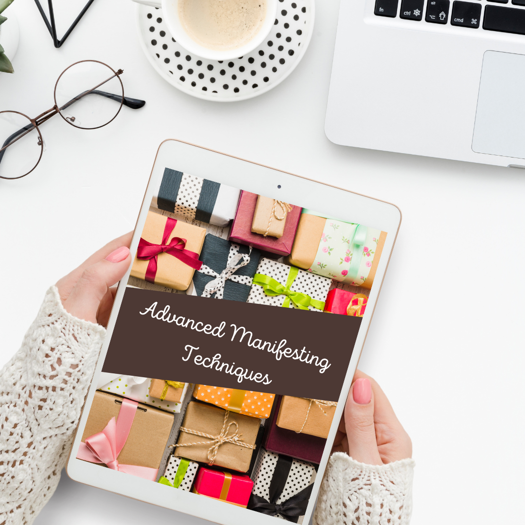 Person holding a tablet with gift boxes on screen and 'Advanced Manifesting Techniques' text representing a digital book