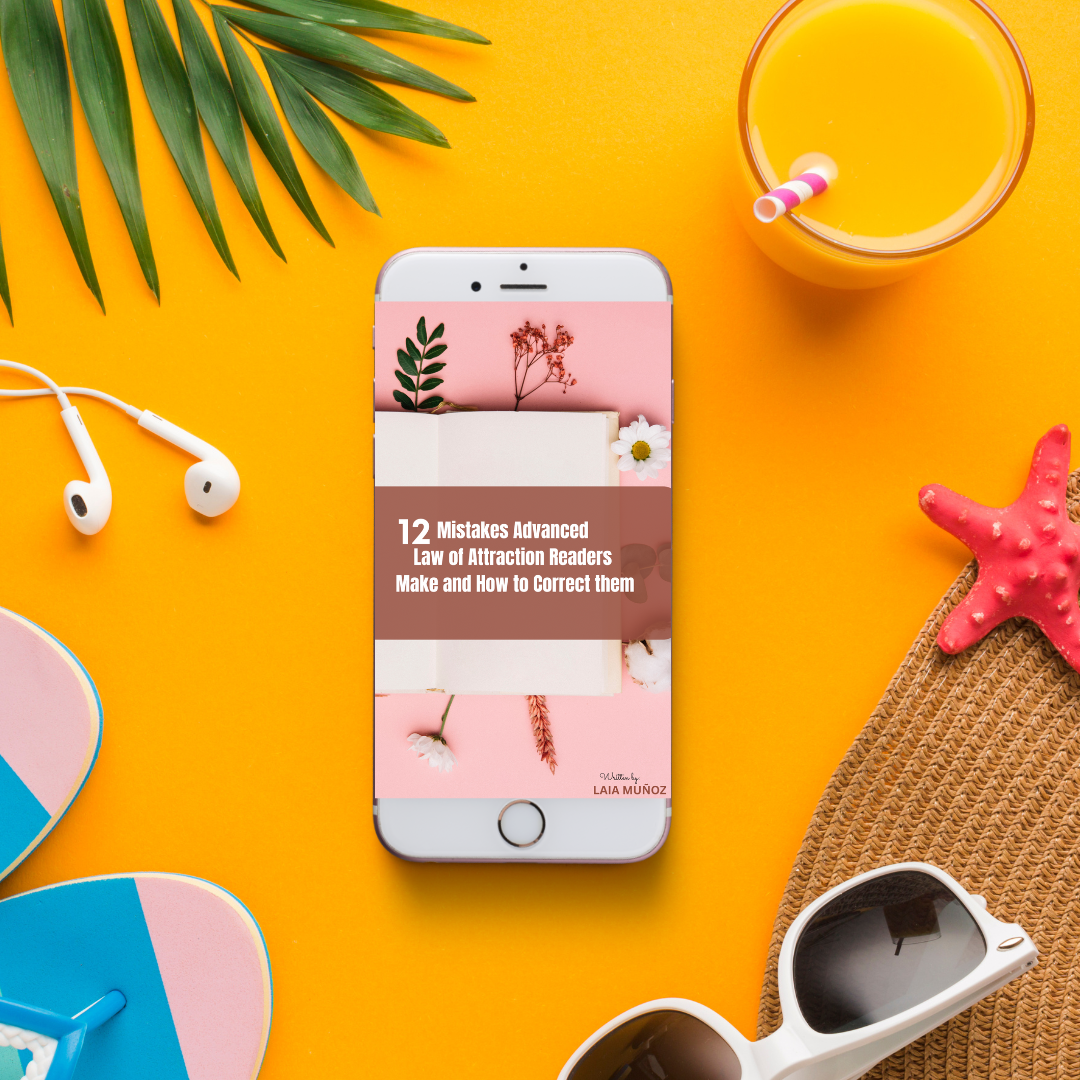 Phone displaying a book cover on an orange background with sunglasses, a straw drink, and leaves, the title of the ebook is " 12 Miatkes Advanced law of Attraction readers make and how to correct them