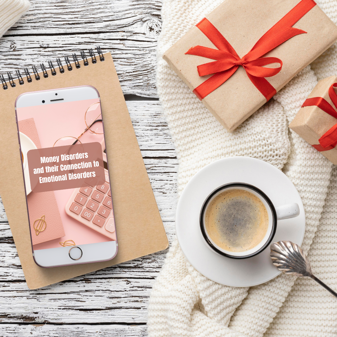 Phone with a book on a wooden surface, next to a cup of coffee and wrapped gifts that features a digital guide called that talks about money mindset