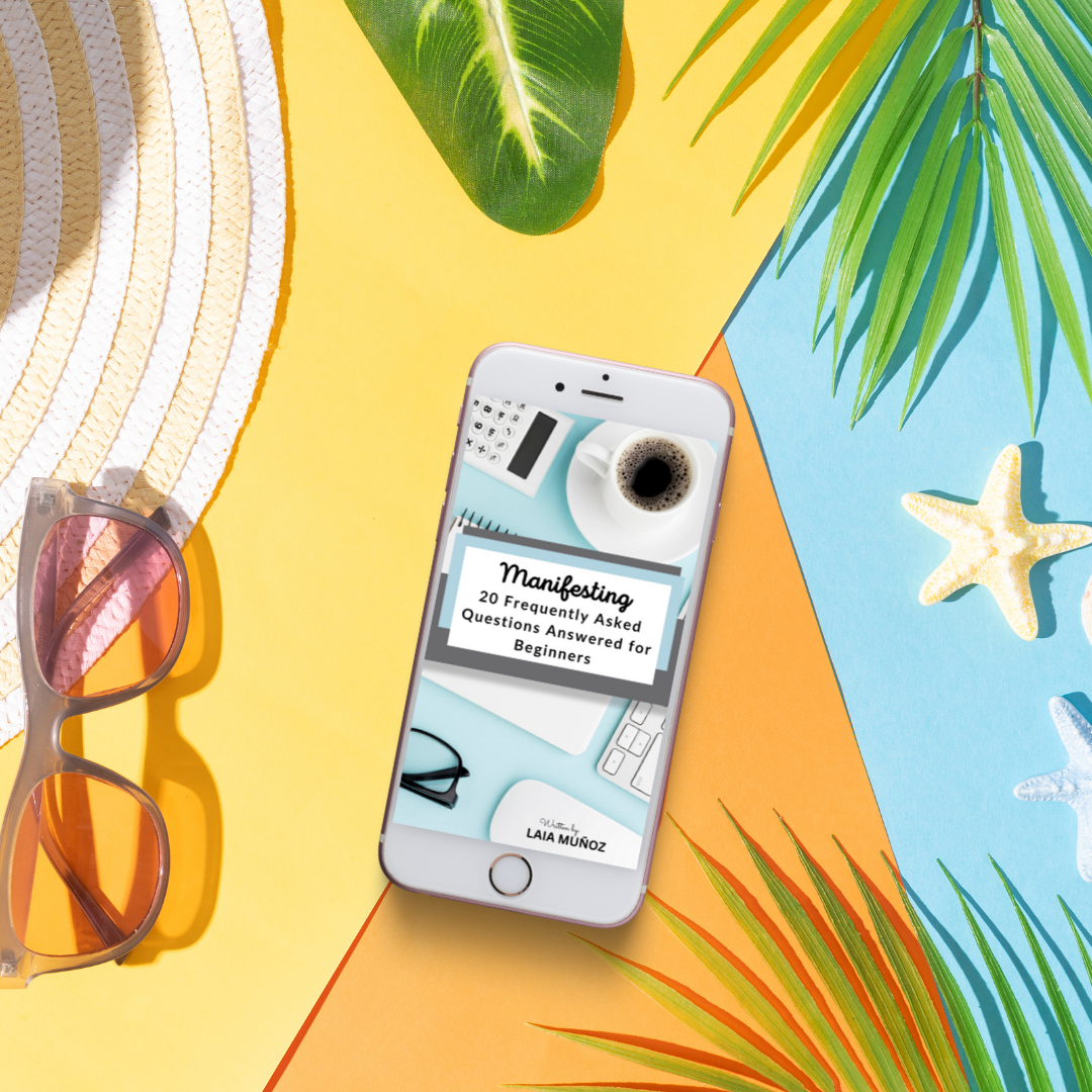 a phone and sunglasses in a summer environment featuring an ebook titled " manifesting 20 FAQS for beginners "  and you can buy it at laiamunozauthor.com