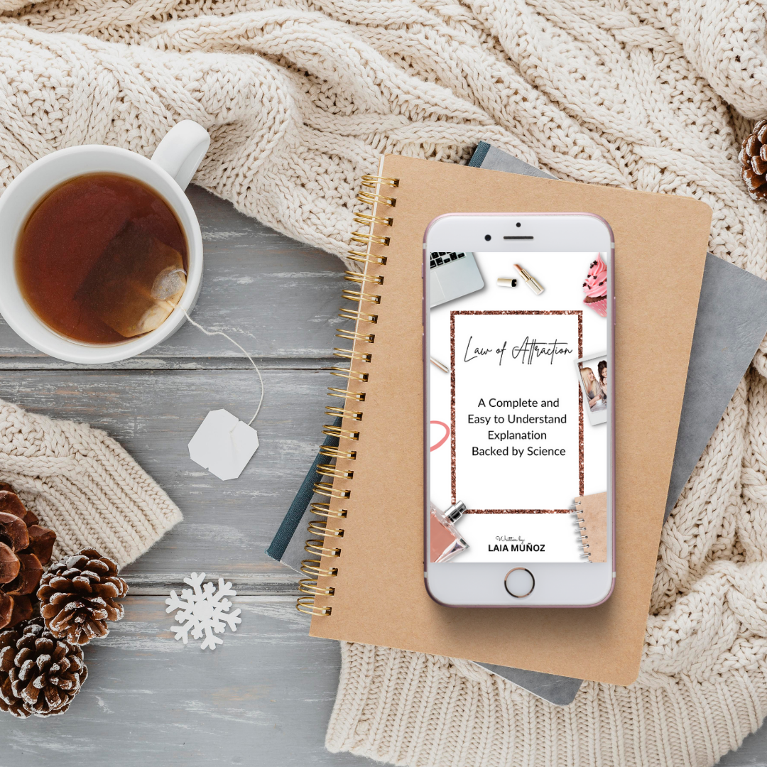 a phone and tea featuring the book law of attraction explanation and you can buy it at laiamunozauthor.com