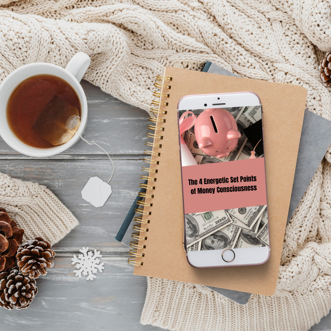 Phone with money-themed app on a notebook next to a cup of tea and decorative items that represents an ebook mockup called · the 4 energetic set points of money consciousness "