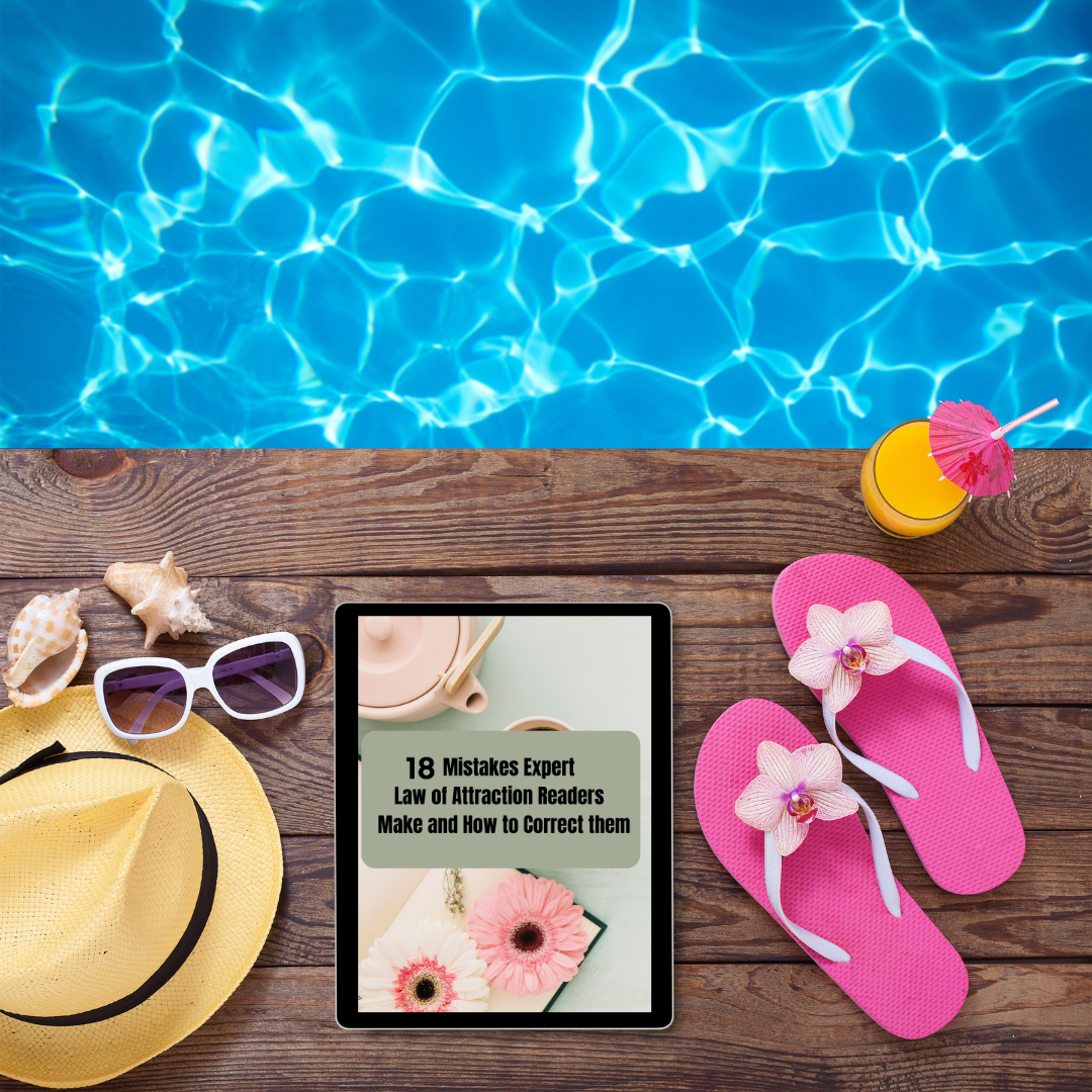 Tablet with a book cover displayed on a wooden table by a poolside with flip-flops, sunglasses, and a hat that represents a digital book titled " mistakes expert law of attraction make "