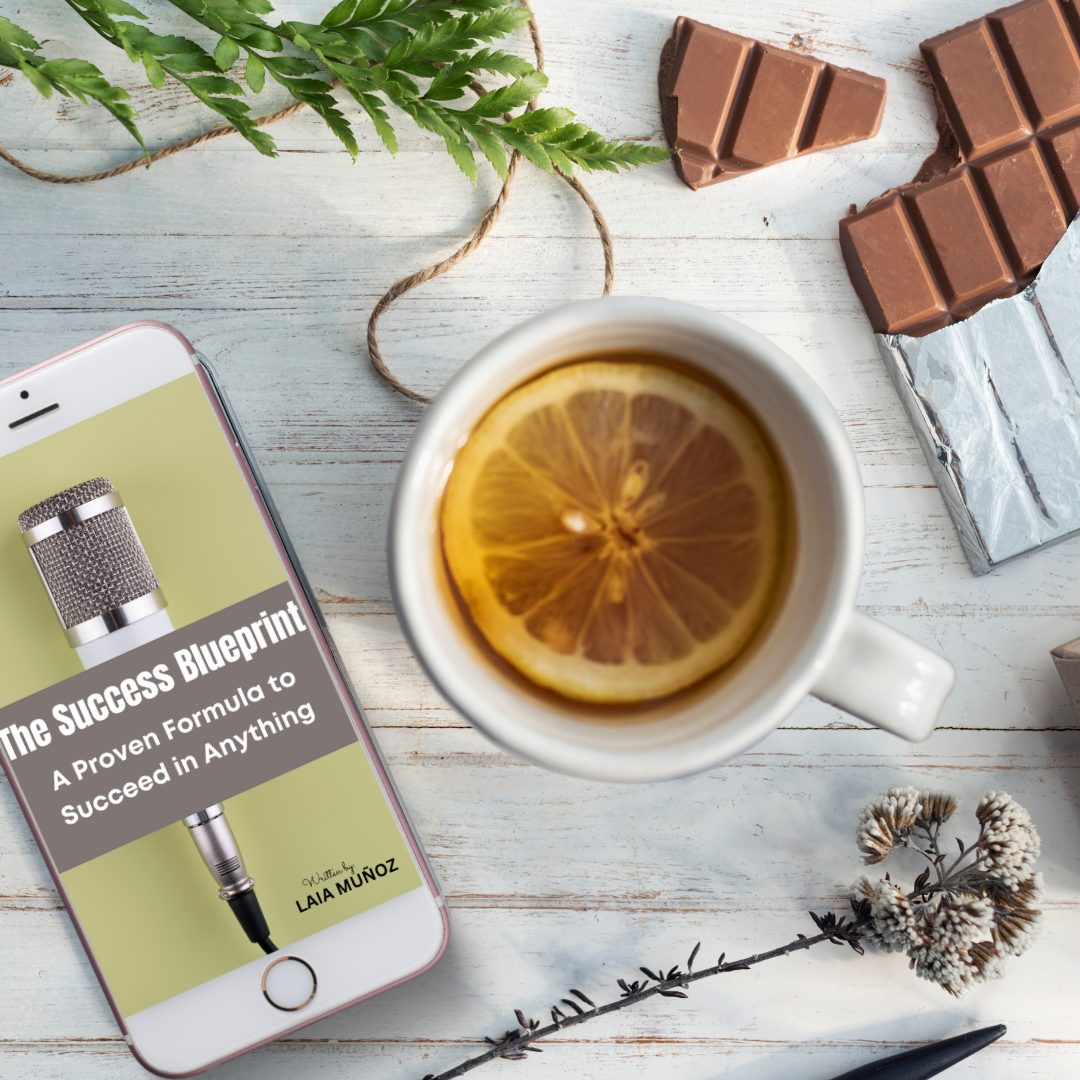 a phone and a piece of chocolate featuring a digital guide called The success blueprint and you can get it at laiamunozauthor.com